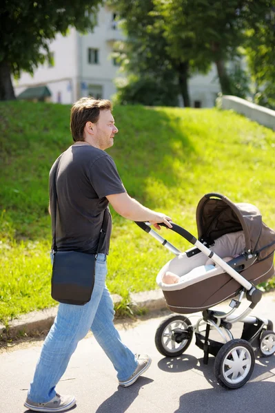 Homem andando com carrinho de bebê — Fotografia de Stock