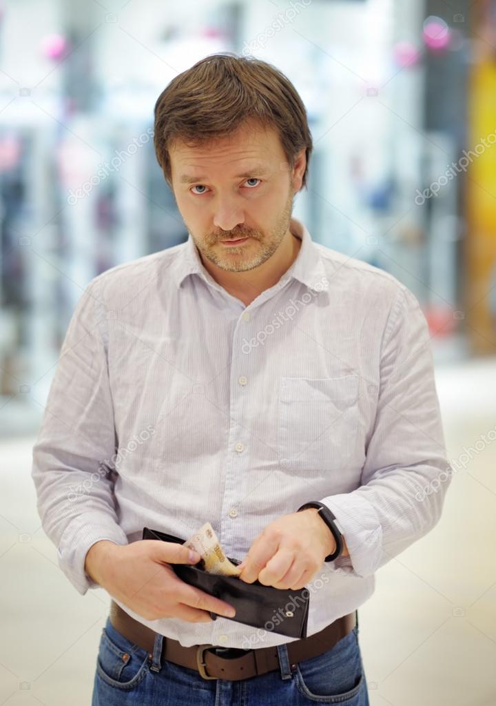 Stressed middle age man holding purse with russian paper money