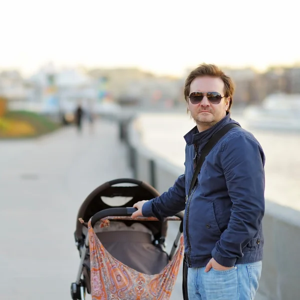 Homme marchant avec poussette bébé — Photo