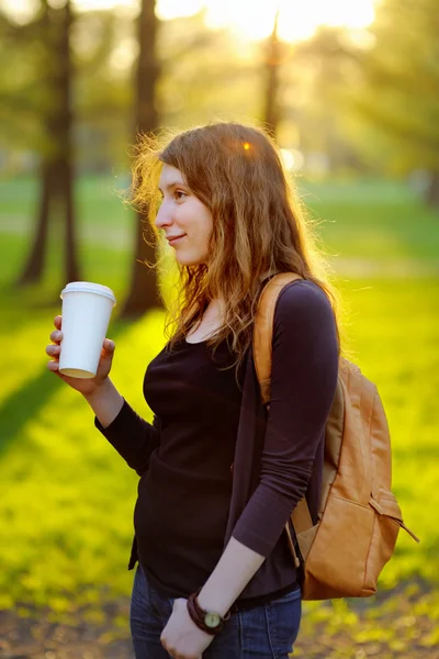 Щаслива молода жінка п'є каву — стокове фото