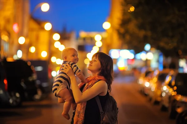 Donna con il suo bambino nella città di notte — Foto Stock