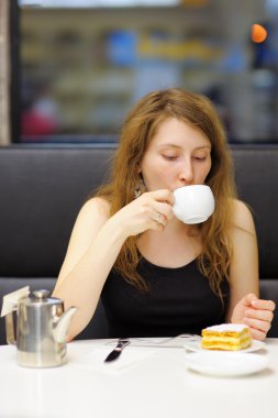 Young woman in a cafe clipart