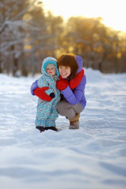 Kış parkta yürümeye başlayan çocuk kadınla