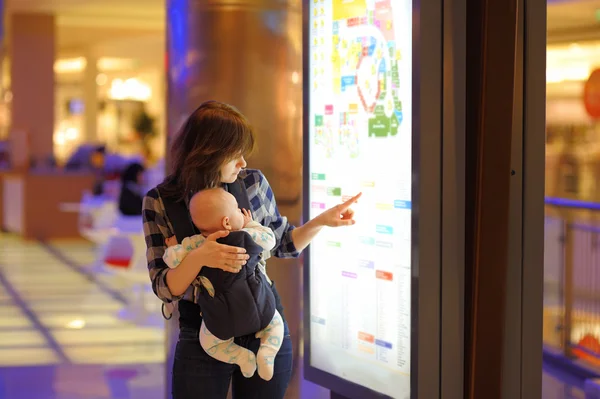 Vrouw met haar baby in een winkelcentrum — Stockfoto