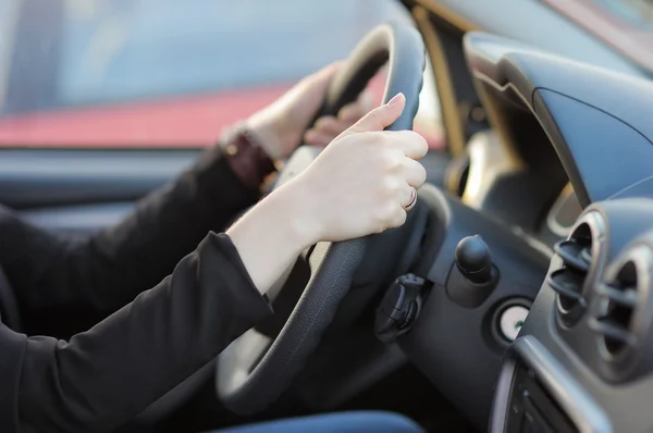 Ręce młoda kobieta trzymając kierownicę — Zdjęcie stockowe