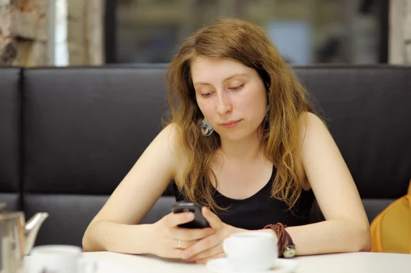 Jonge vrouw in een cafe — Stockfoto