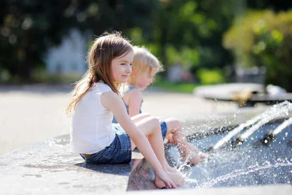 Deux sœurs s'amusent dans une fontaine — Photo