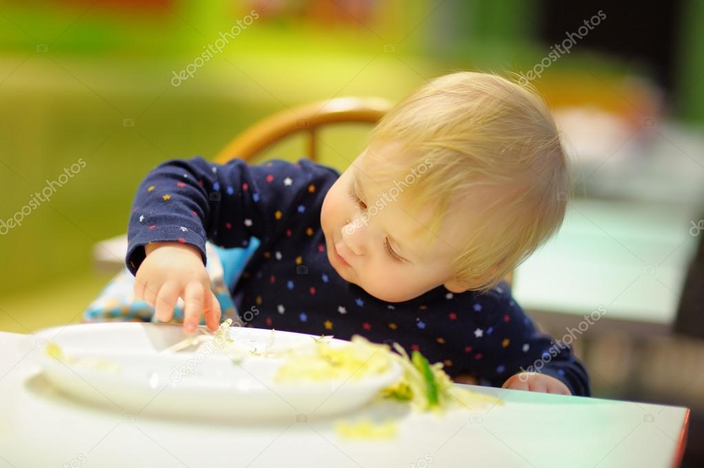 Toddler boy playing with food