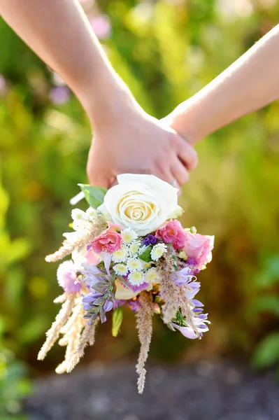 Couple holding wild flowers bouquet — Stock Photo, Image
