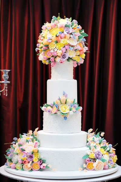 Köstliche weiße Hochzeitstorte mit cremefarbenen Blüten — Stockfoto