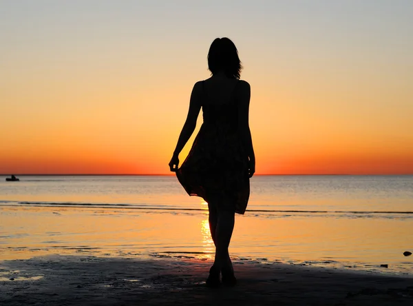 Vrouw als silhouet door de zee — Stockfoto