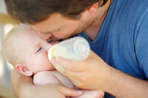 Малыш пьет молоко из бутылки. — стоковое фото