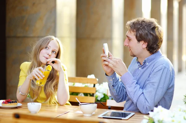 Uomo scattare foto di giovane donna utilizzando il suo smartphone — Foto Stock