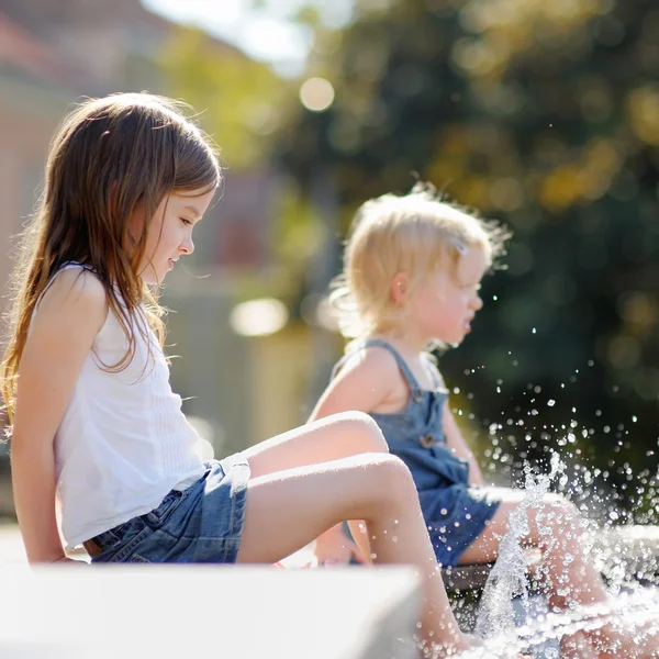 Petites sœurs s'amusent dans une fontaine — Photo