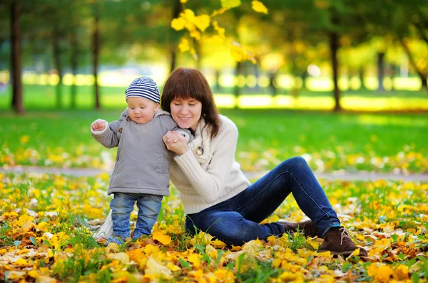 Jonge moeder met haar baby in het najaar — Stockfoto