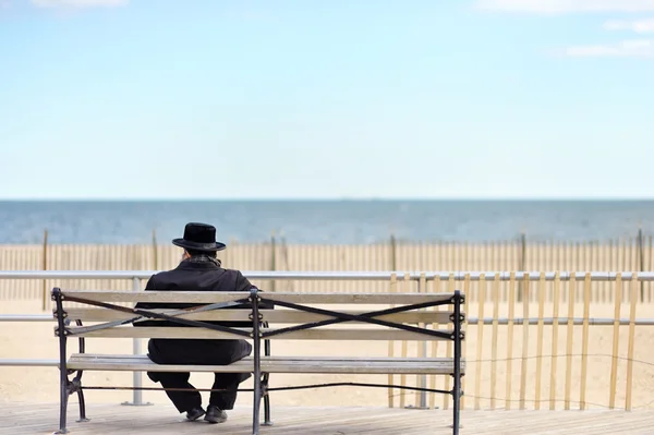 Homme juif assis sur un banc près de l'océan — Photo