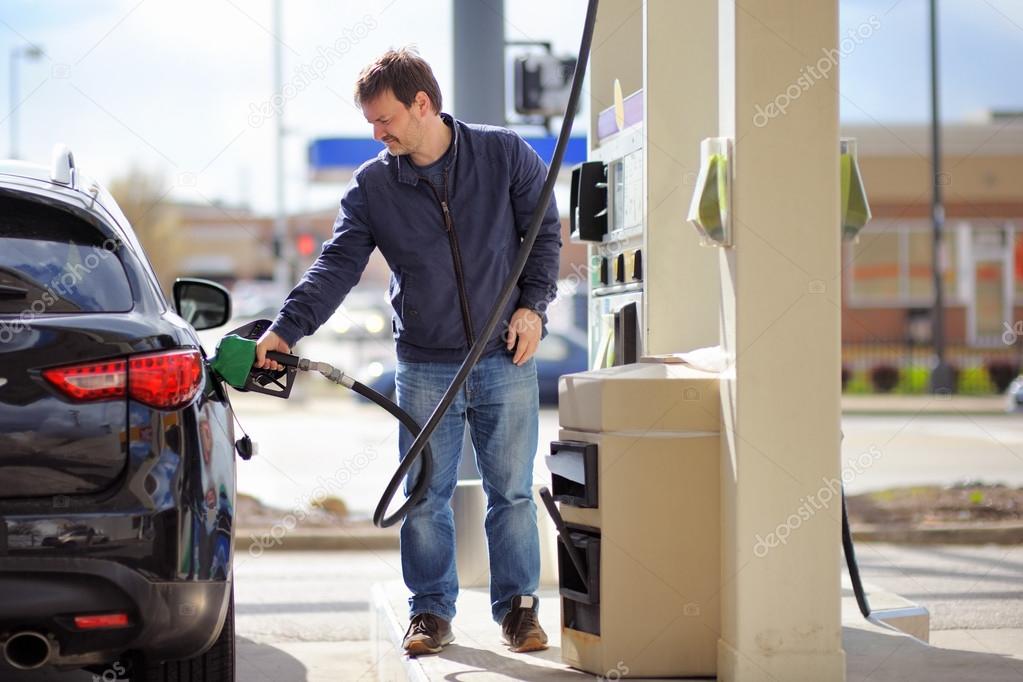 Man filling gasoline fuel in car 