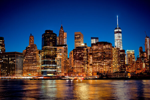 New York City Manhattan downtown skyline at night with illuminated skyscrapers