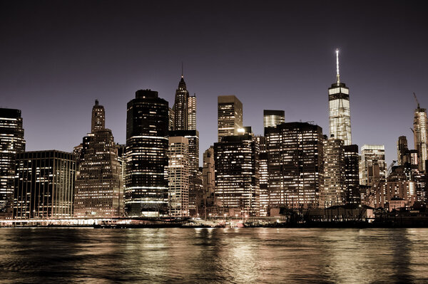 New York City Manhattan downtown skyline at night with illuminated skyscrapers, vintage filter