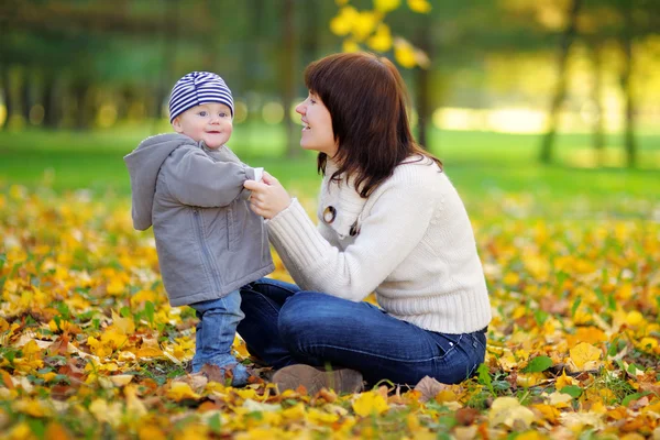 Jovem mãe com seu bebê no parque de outono — Fotografia de Stock