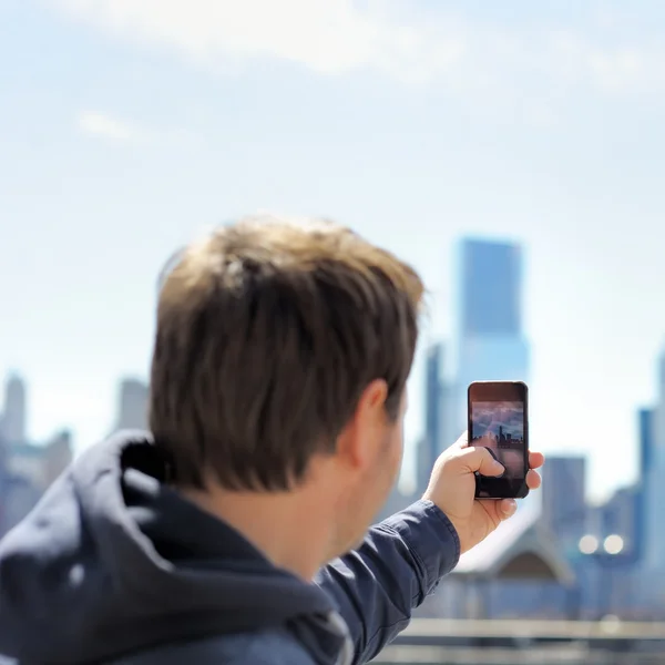Turist fotografiind pe mobil zgârie-nori — Fotografie, imagine de stoc