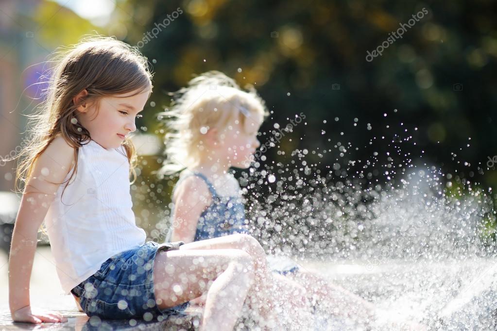 Sisters having fun in a fountain