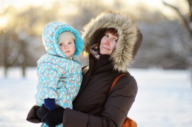 Beautiful woman and her little grandson at the winter clipart