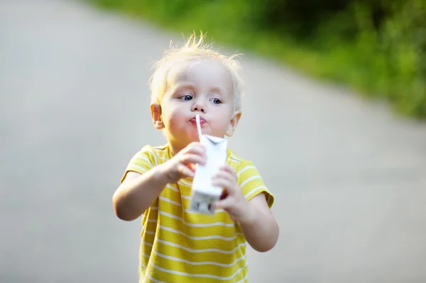 Niño pequeño bebiendo leche o jugo —  Fotos de Stock