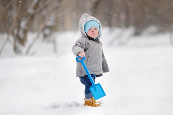 Schöner kleiner Junge, der mit Schnee spielt — Stockfoto