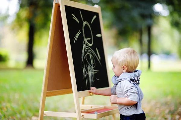 Småbarn pojke teckning stående av en svart tavla — Stockfoto