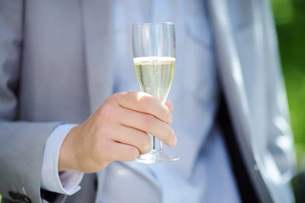 Uomo in possesso di vetro con champagne — Foto Stock