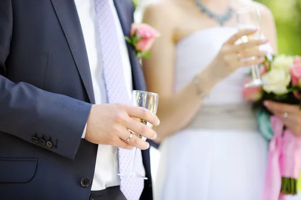 Nevěsta a ženich držení skleničky — Stock fotografie