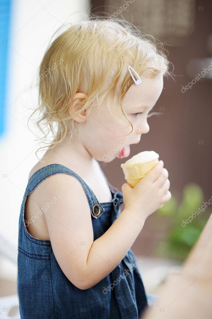 Adorable toddler girl eating ice cream