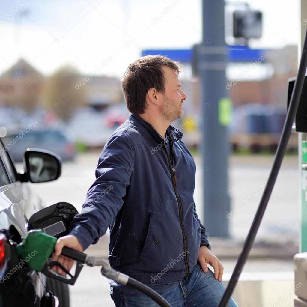 Man filling gasoline fuel in car