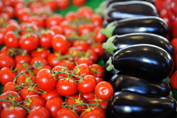 Färska röda körsbärstomater och aubergine — Stockfoto