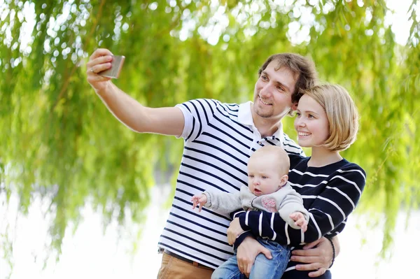 Jonge ouders maken een zelfportret met hun babymeisje — Stockfoto