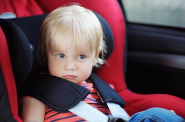 Araba koltuğuna oturan yürümeye başlayan çocuk