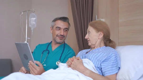 Doutor Conversando Com Paciente Sênior Com Tablet Cama Hospital — Fotografia de Stock