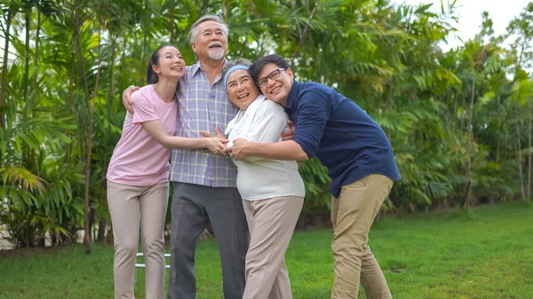 緑の草の中の幸せなアジアの家族は — ストック写真