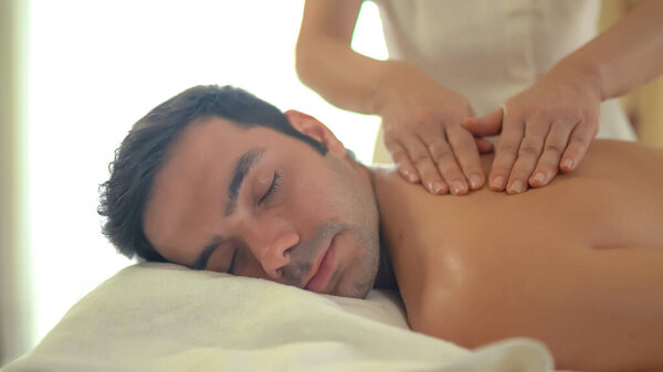 Молодой кавказский мужчина расслабляется во время массажа на спине