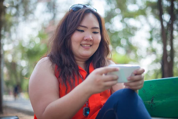 Mulher gorda feliz usando telefone celular — Fotografia de Stock