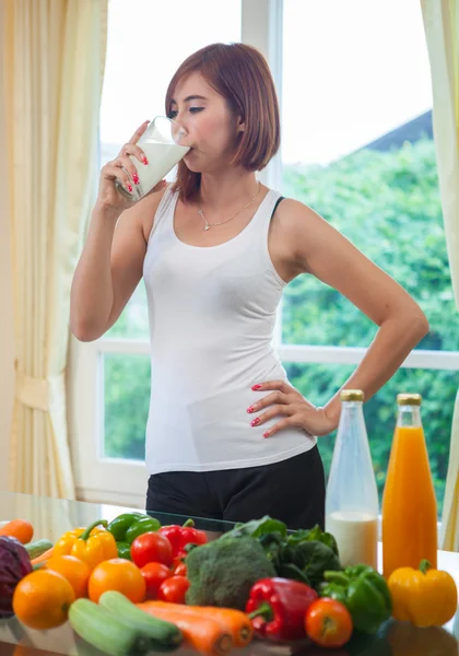 Junge asiatische Frau trinkt Milch — Stockfoto