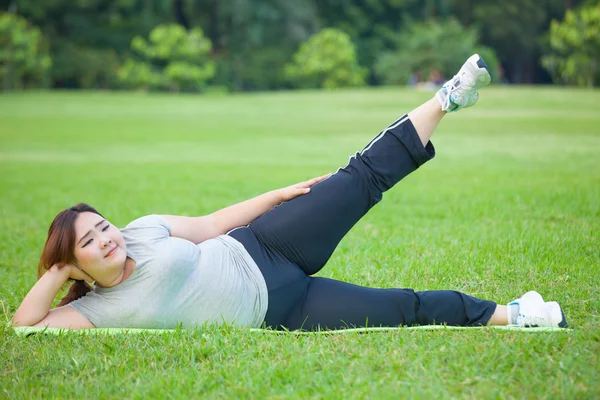 Mujer gorda acostada por ejercicio pierna hacia arriba —  Fotos de Stock