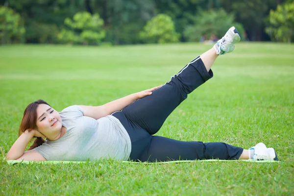 Mulher gorda deitada por exercício perna para cima — Fotografia de Stock