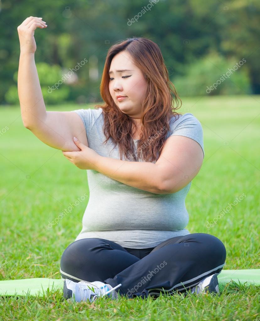 Young woman checking her arm fat — Stock Photo © WitthayaP 61268123