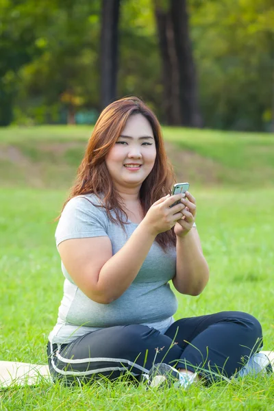 Mulher gorda feliz usando telefone celular — Fotografia de Stock