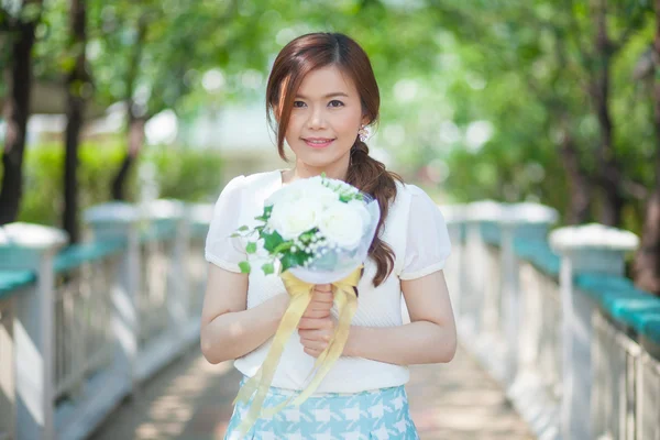 Jovem asiático bonito mulher cheirando flores brancas — Fotografia de Stock