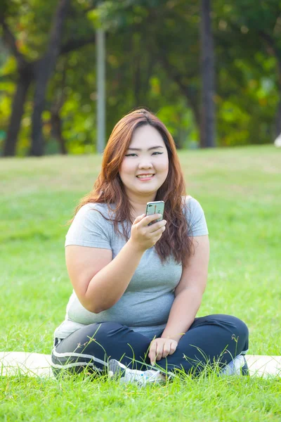 Szczęśliwy tłuszczowych kobieta przy użyciu telefonu komórkowego — Zdjęcie stockowe