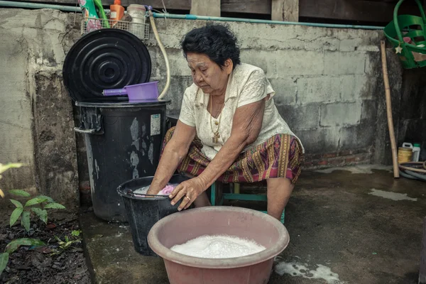 Senior asiatisk kvinna tvätta kläder för hand — Stockfoto