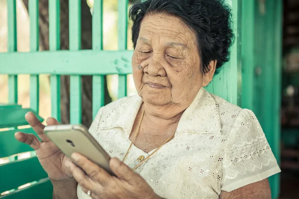 Senior mujer asiática con teléfono inteligente — Foto de Stock